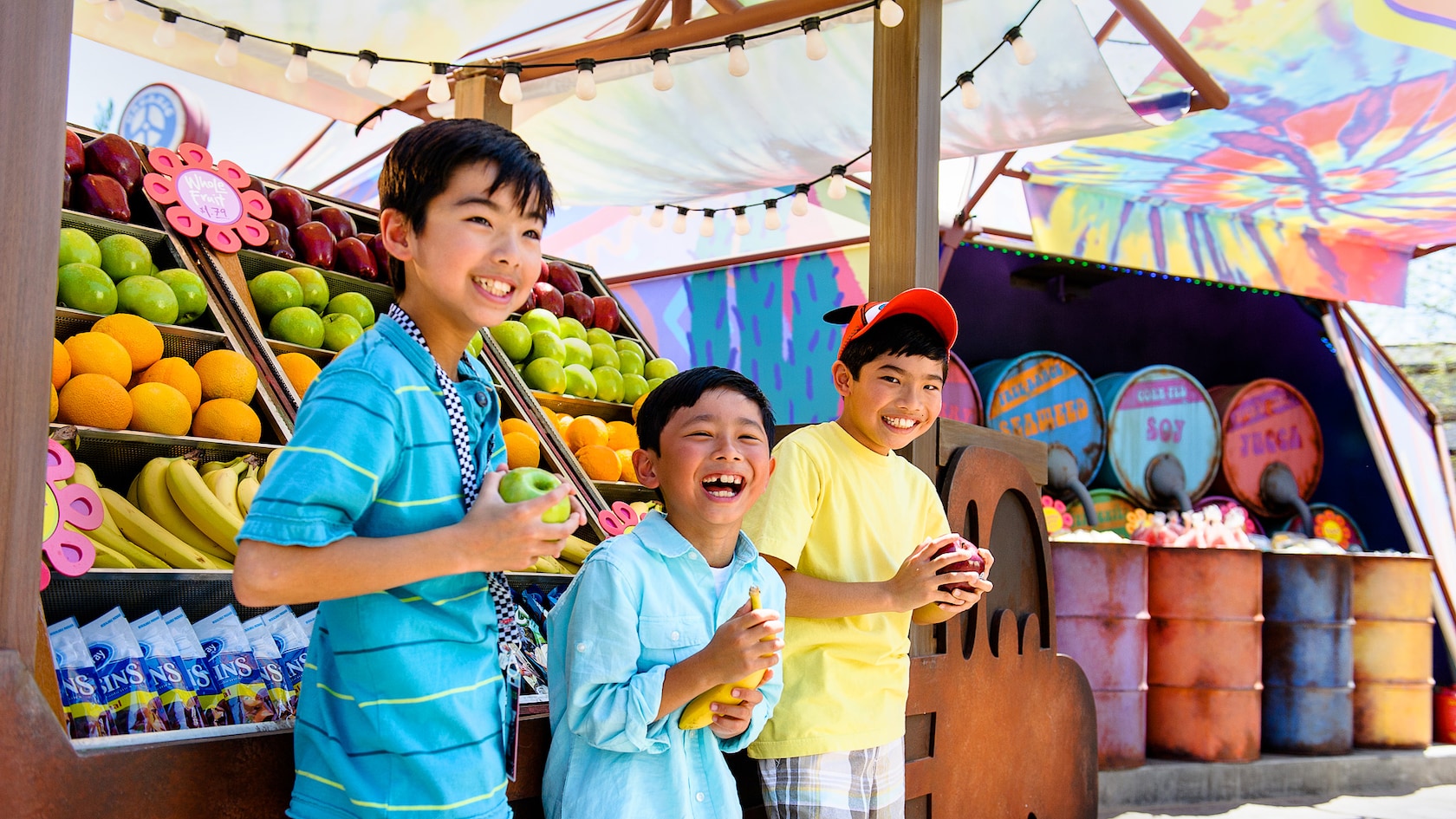 3 happy boys select fruit from Fillmore's Taste-In snack stand at Disney California Adventure Park