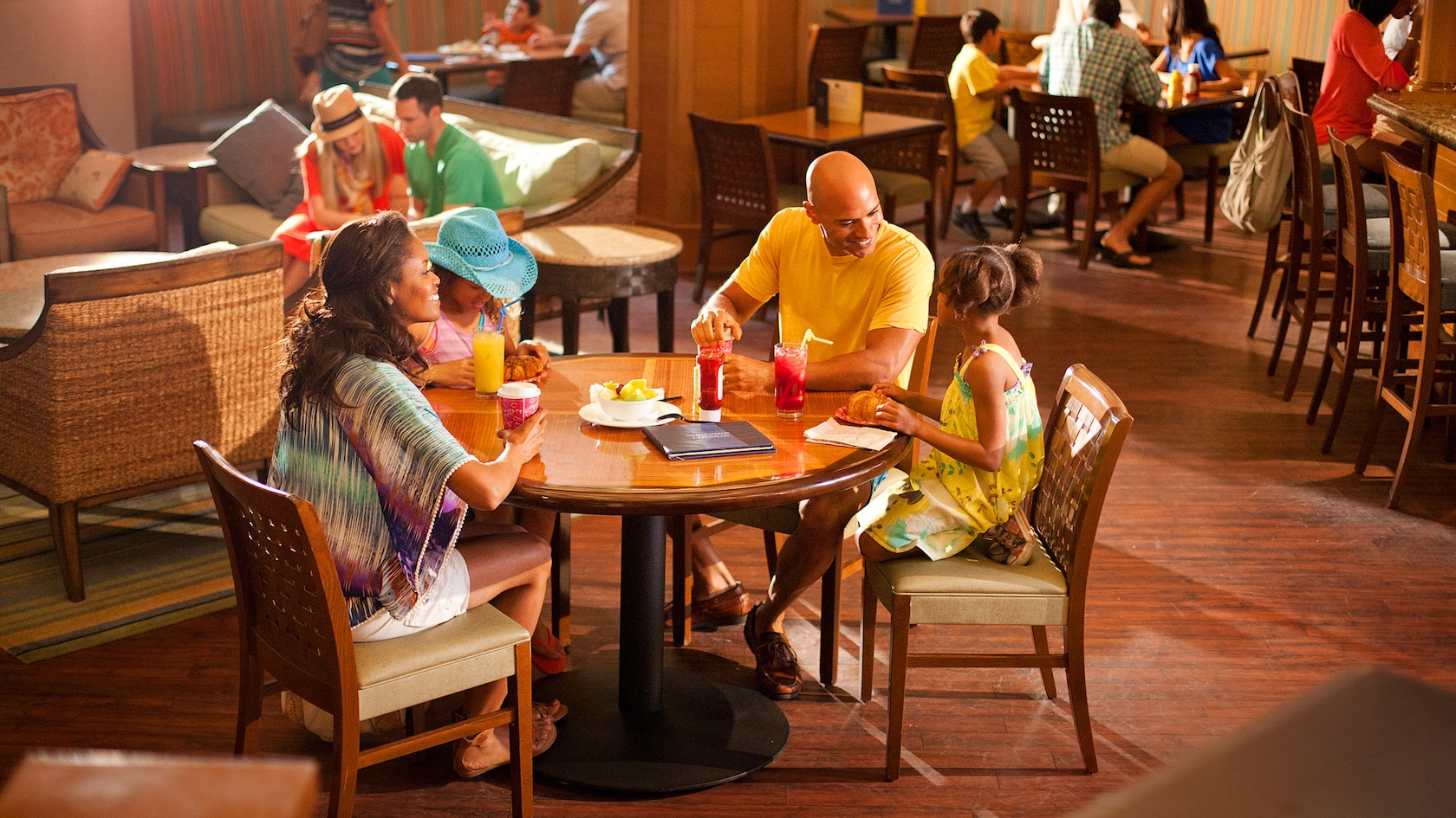 Una familia se relaja con bebidas y un antojito en Surfside Lounge, un restaurante de Paradise Pier Hotel