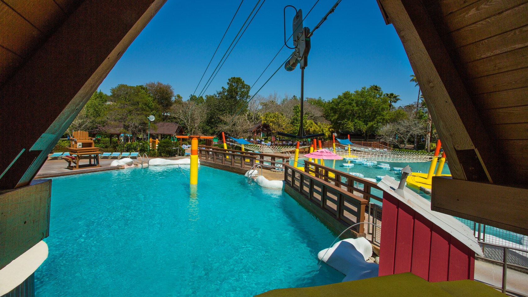 The thick cable of a zip line suspended over a pool at Fahrenheit Drops 