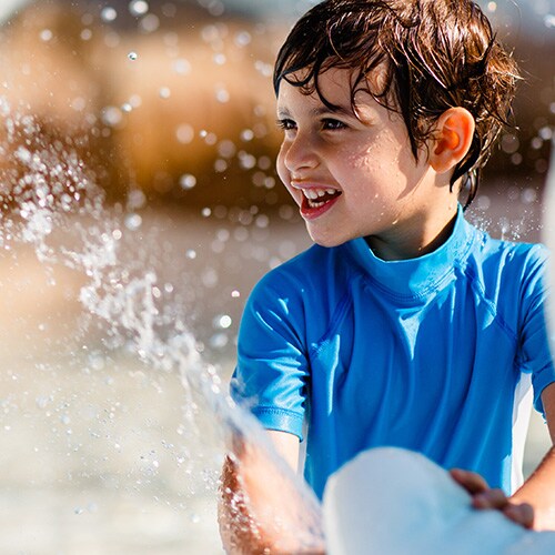 A boy squirts water from an ice sculpture at Tike's Peak, a polar-themed water play area