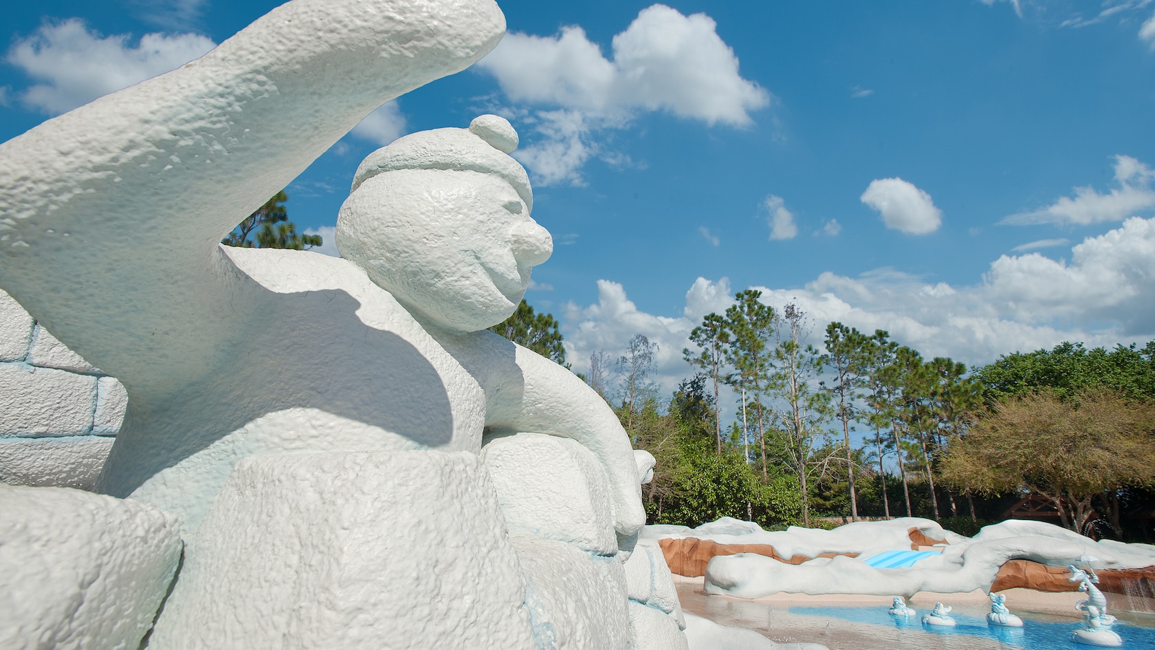 A snowman ice sculpture looking onto a wading pool at Tike's Peak