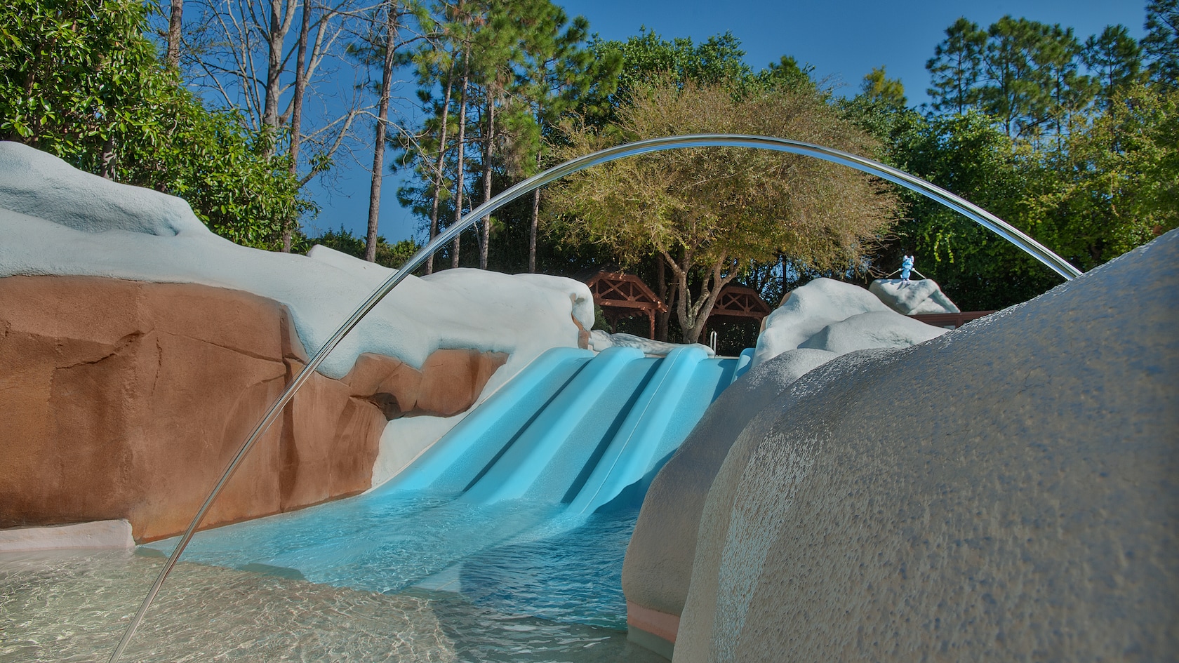 Three small side-by-side downhill waterslides that empty into a wading pool