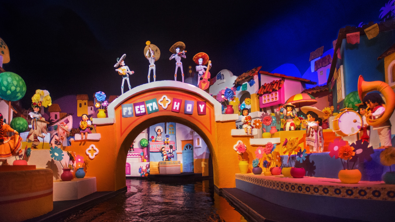 A waterway flanked by Mexican dolls in a village inside the Mexico pavilion at Epcot 