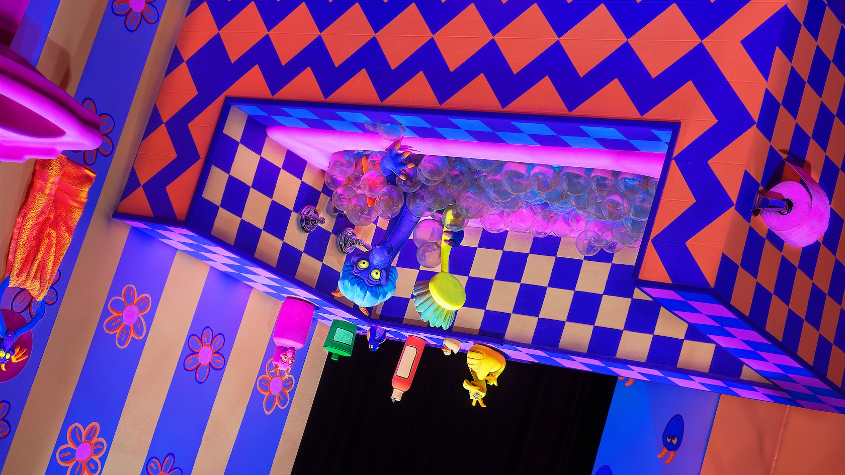 An upside-down bathtub with geometric patterns and Figment taking a bath