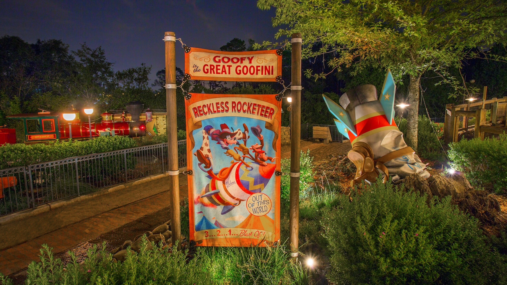 A crashed rocket ship sits next to a sign featuring Goofy as the Reckless Rocketeer