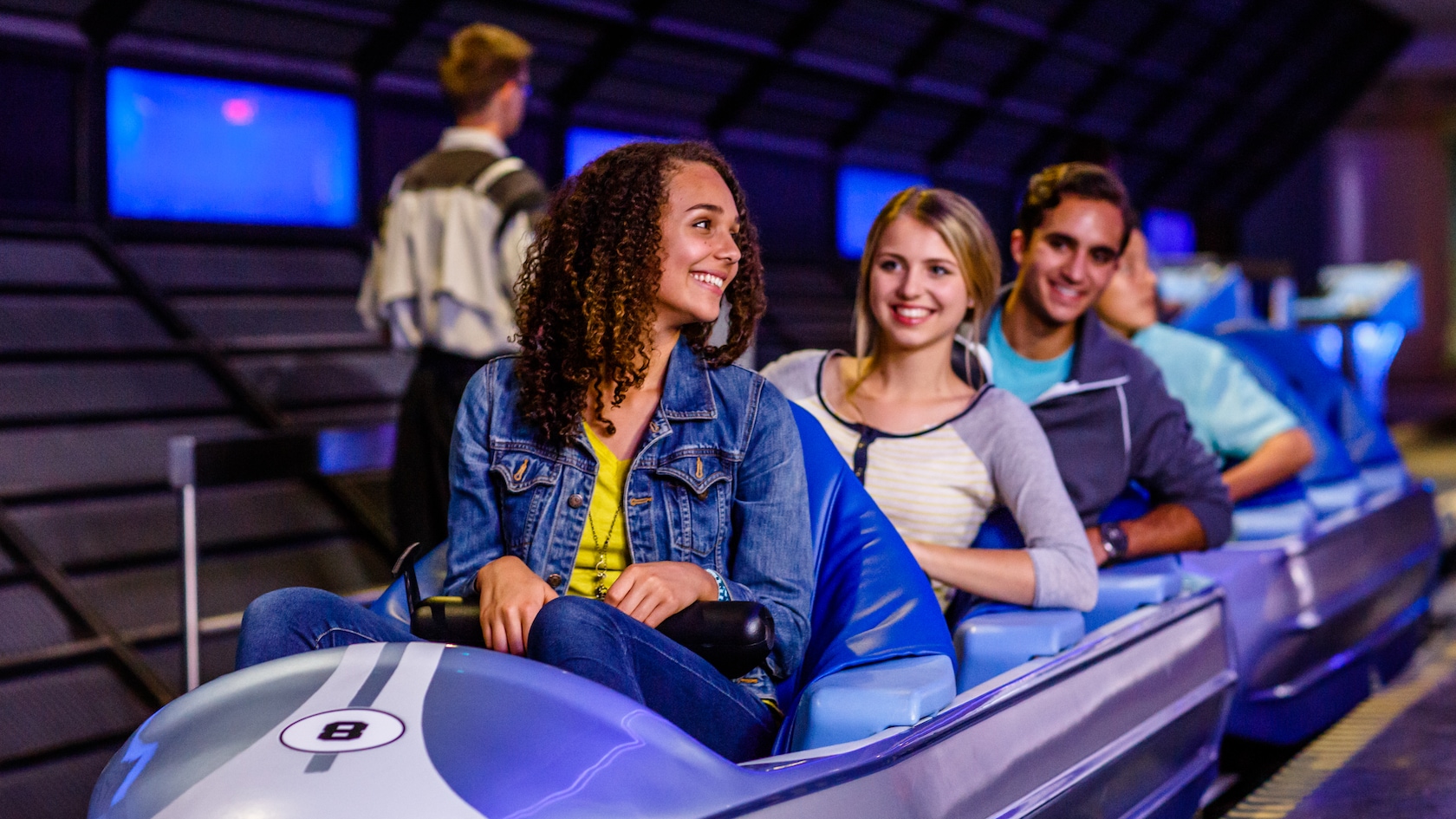 Algunos huéspedes ubicados en un tren con forma de cohete en Space Mountain en Tomorrowland
