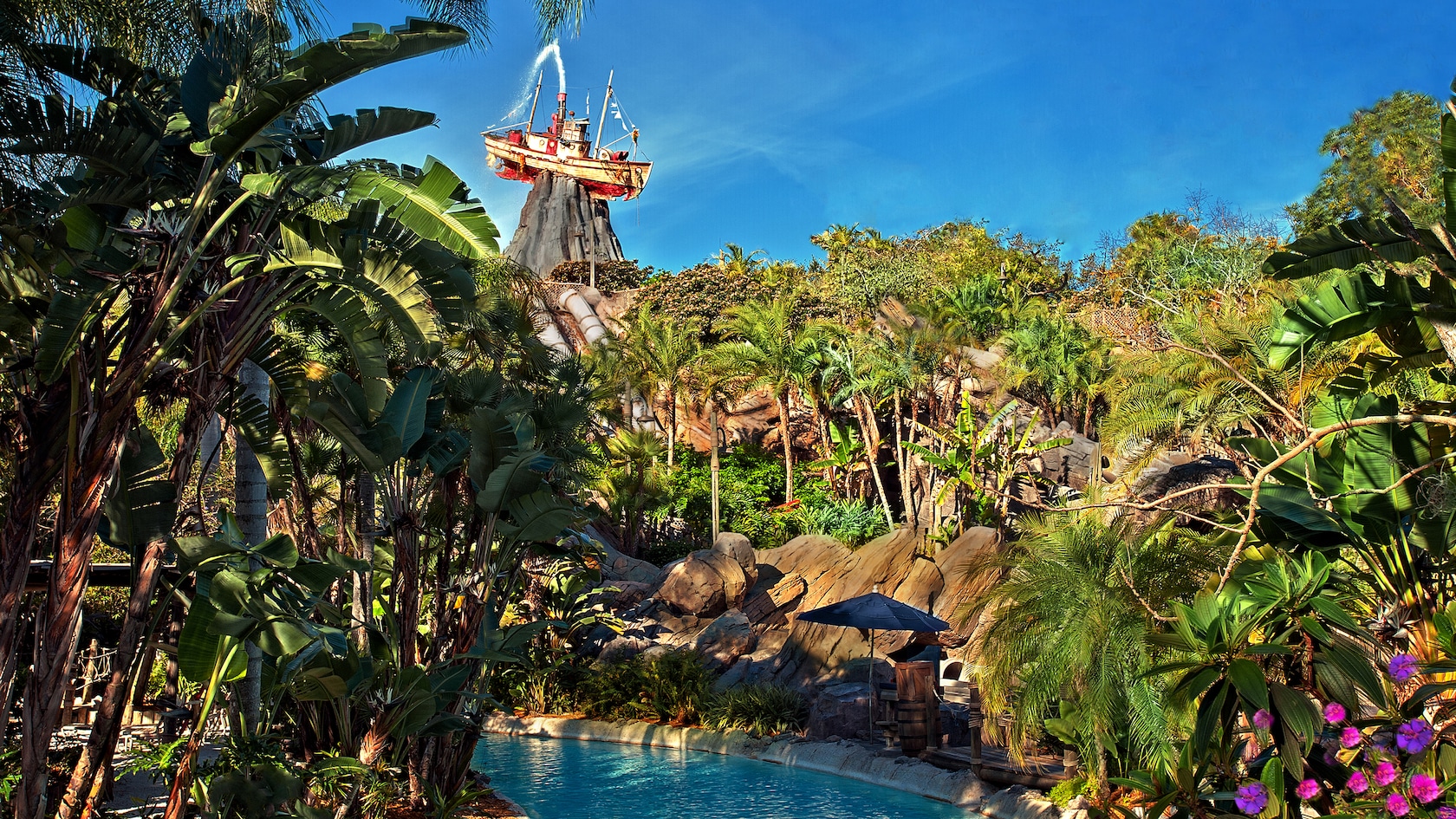 Castaway Creek graced by tropical trees, with iconic Miss Tilly atop Mount Mayday in the background