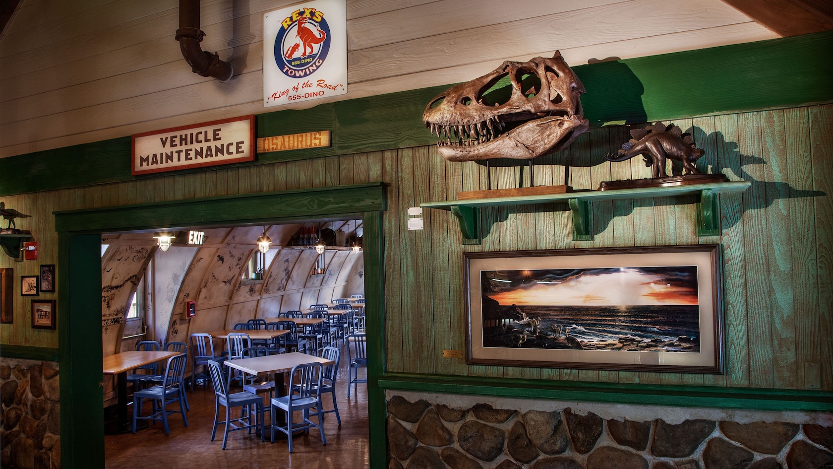 Entrance leading to Quonset hut dining area, signs and dino skull on wall