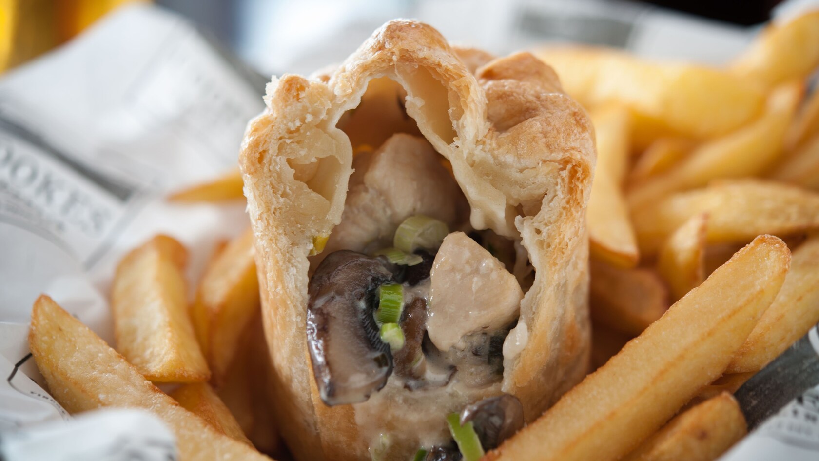 Seção transversal da torta de frango e cogumelos do campo em uma cesta com fritas 