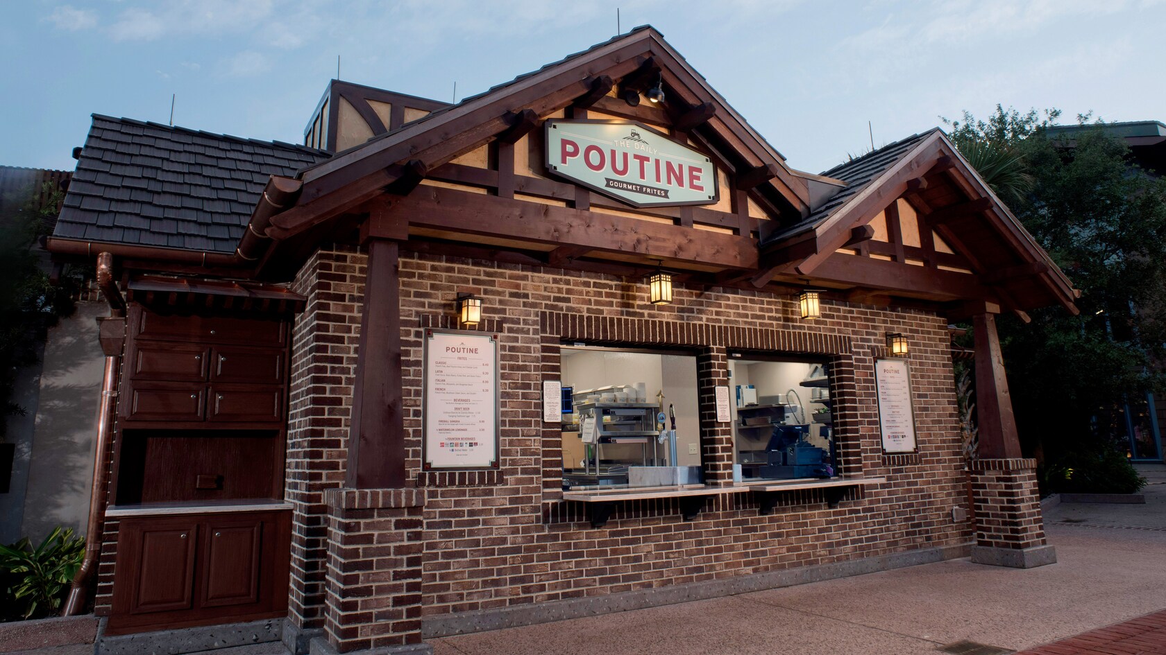 El frente del restaurante The Daily Poutine, en Disney Springs, presenta una fachada de ladrillo con 2 ventanas de servicio, un letrero con el nombre del establecimiento y un techo a dos aguas