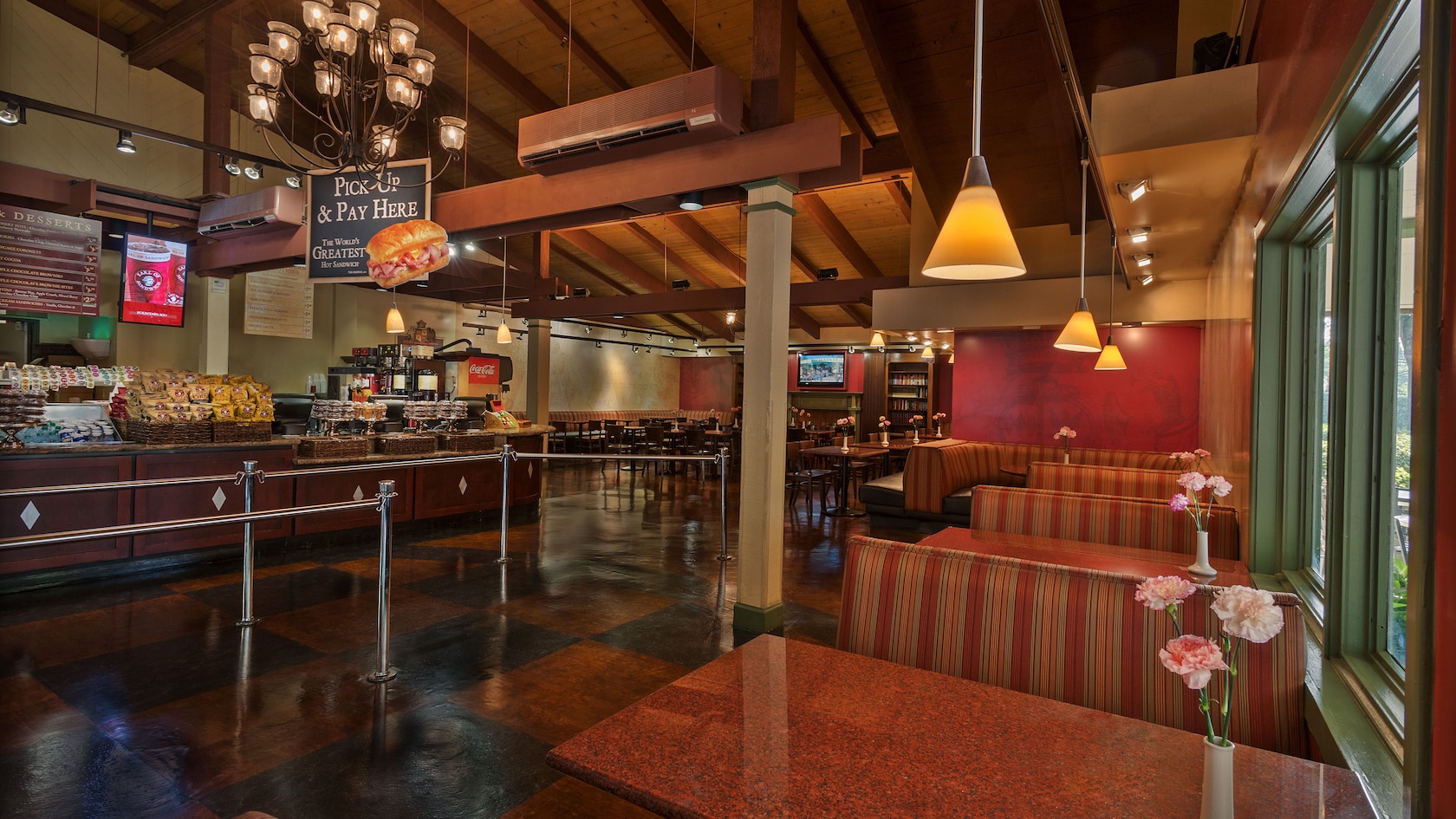 Uma fileira de mesas em frente à área de fila e o balcão de atendimento