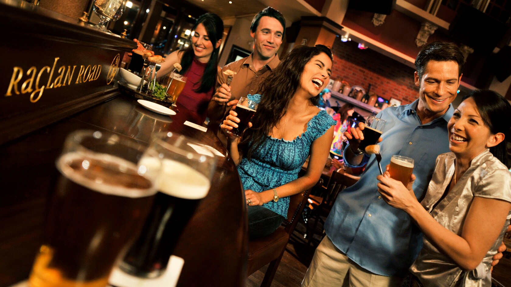 Five young adults enjoying snacks and beer at the bar at Raglan Road Irish Pub and Restaurant