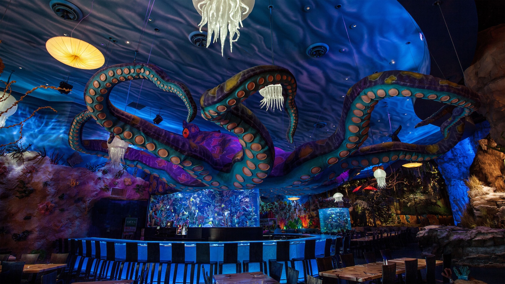 Un pulpo gigante extiende sus tentáculos sobre un bar con un tema submarino