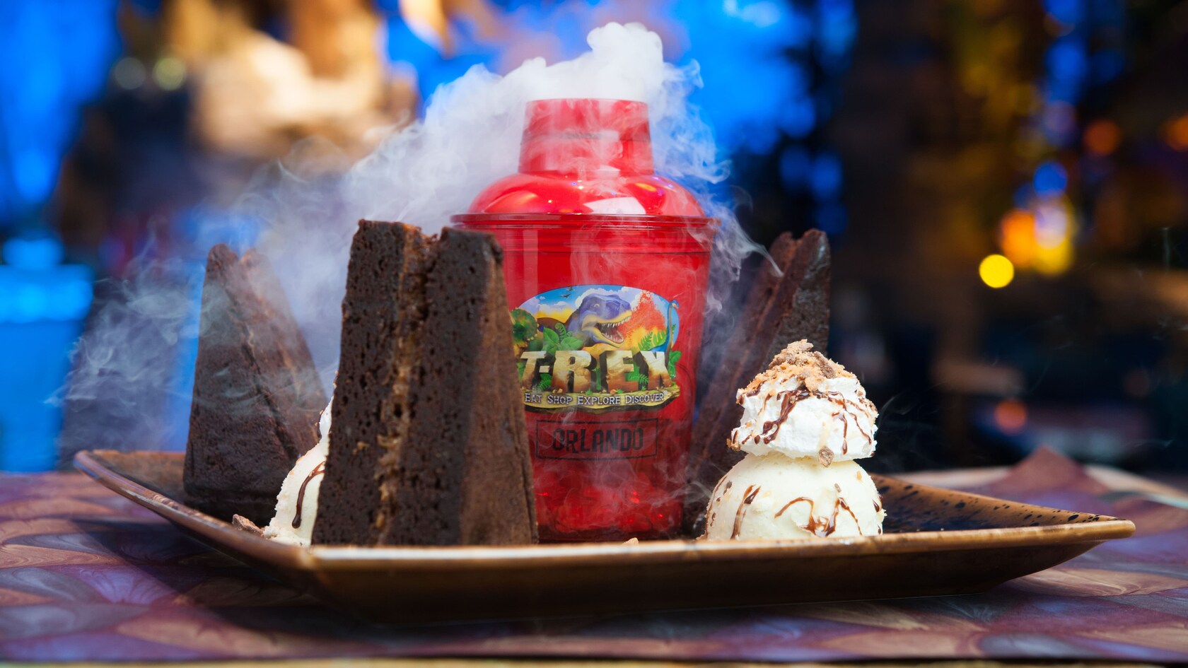 Dos porciones de pastel de chocolate y helado, con un recipiente de hielo seco humeante