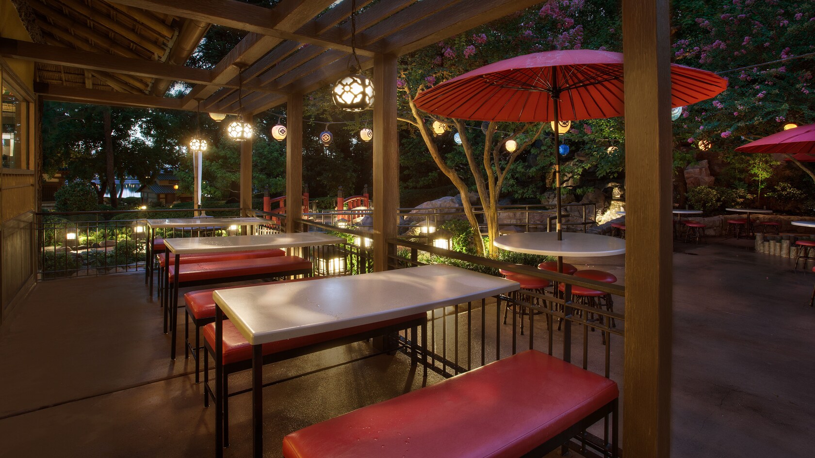 Lighted outdoor seating with rectangular and round tables with umbrella