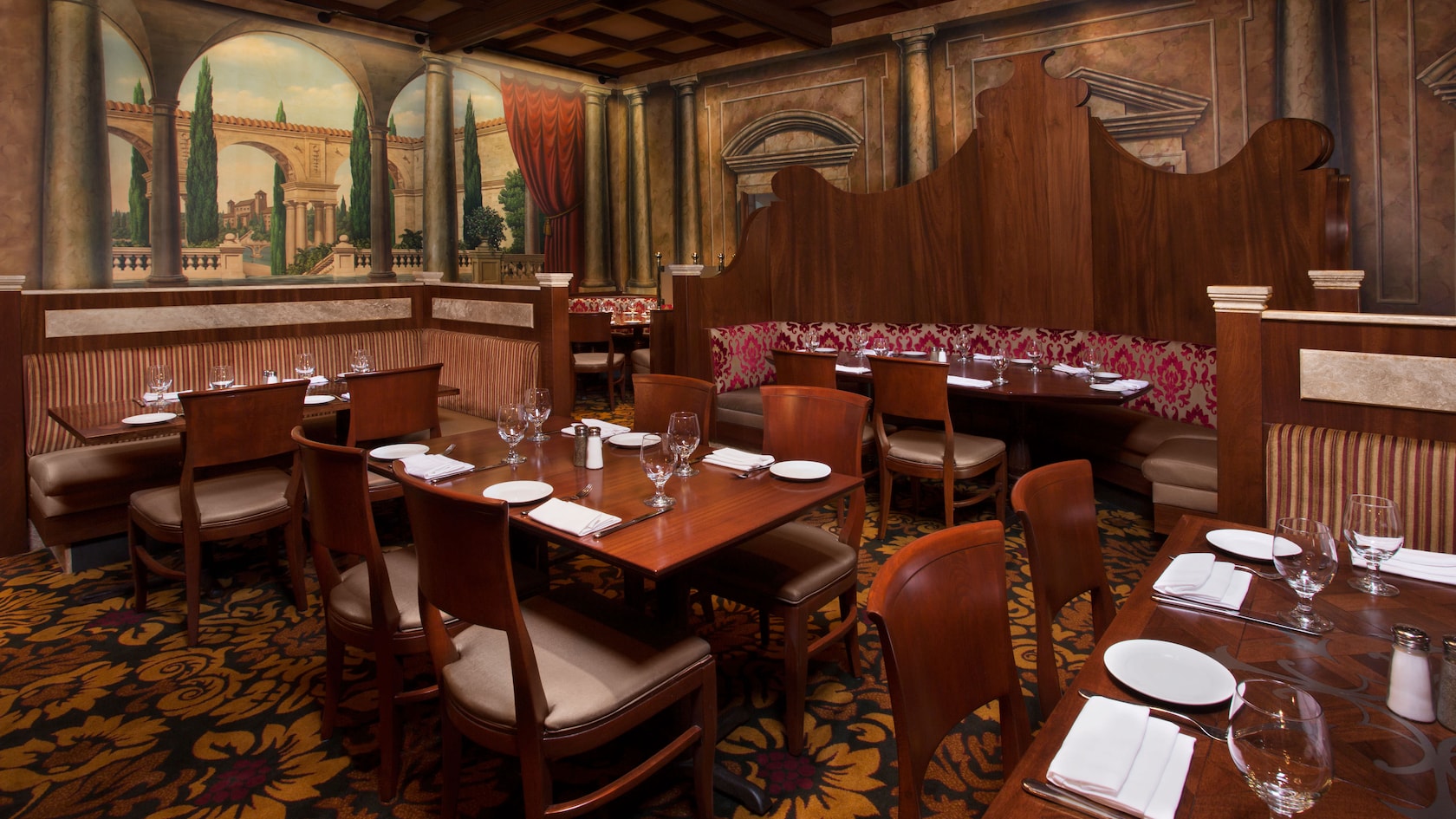 Dining area with booths and tables and murals of Italy