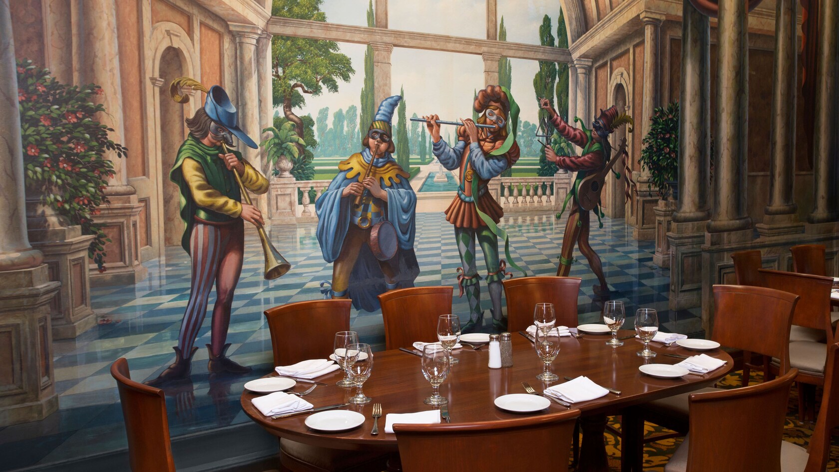An oblong dining table in front of a mural of Italian musicians
