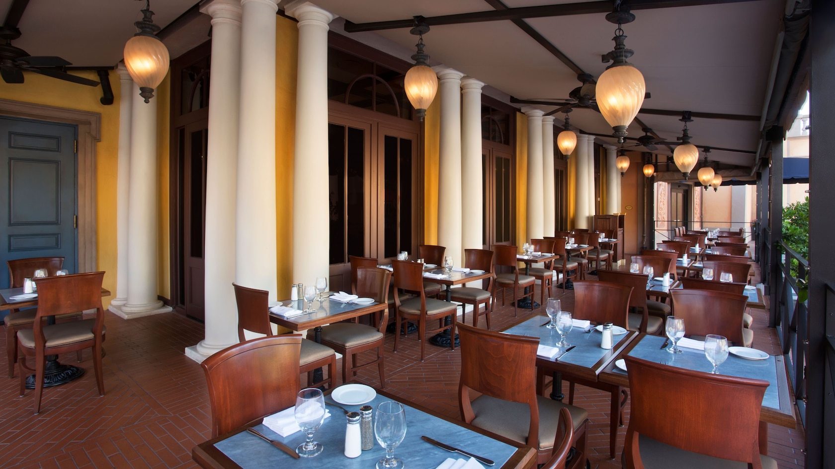 Patio dining area with overhead hanging lights and colonnades