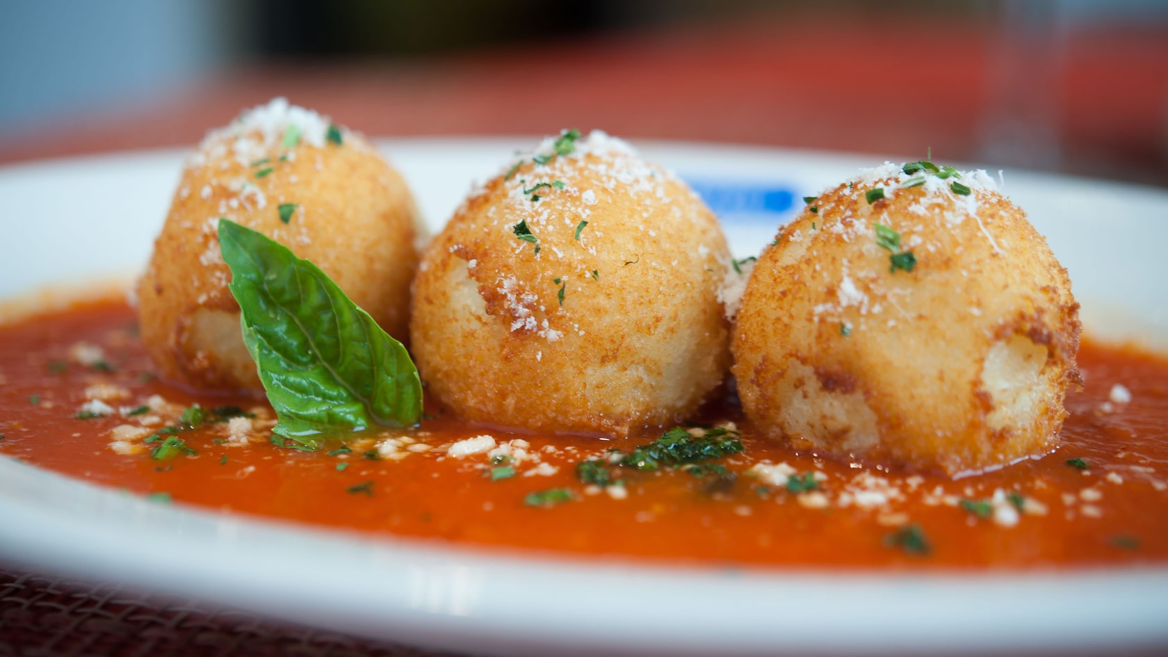 Three fried risotto balls filled with meat ragù and mozzarella
