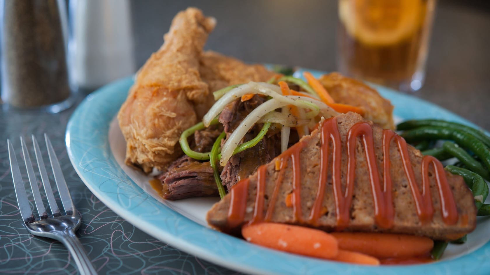 Une assiette de poulet frit croustillant, de rôti et de pain de viande avec tous les accompagnements