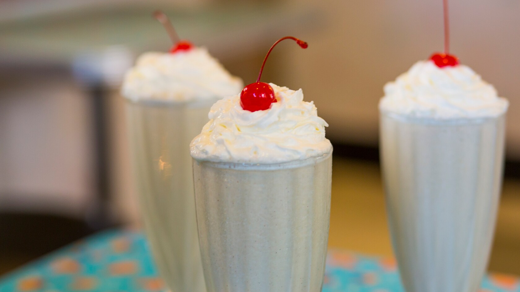 Milkshakes topped with whipped cream and cherries