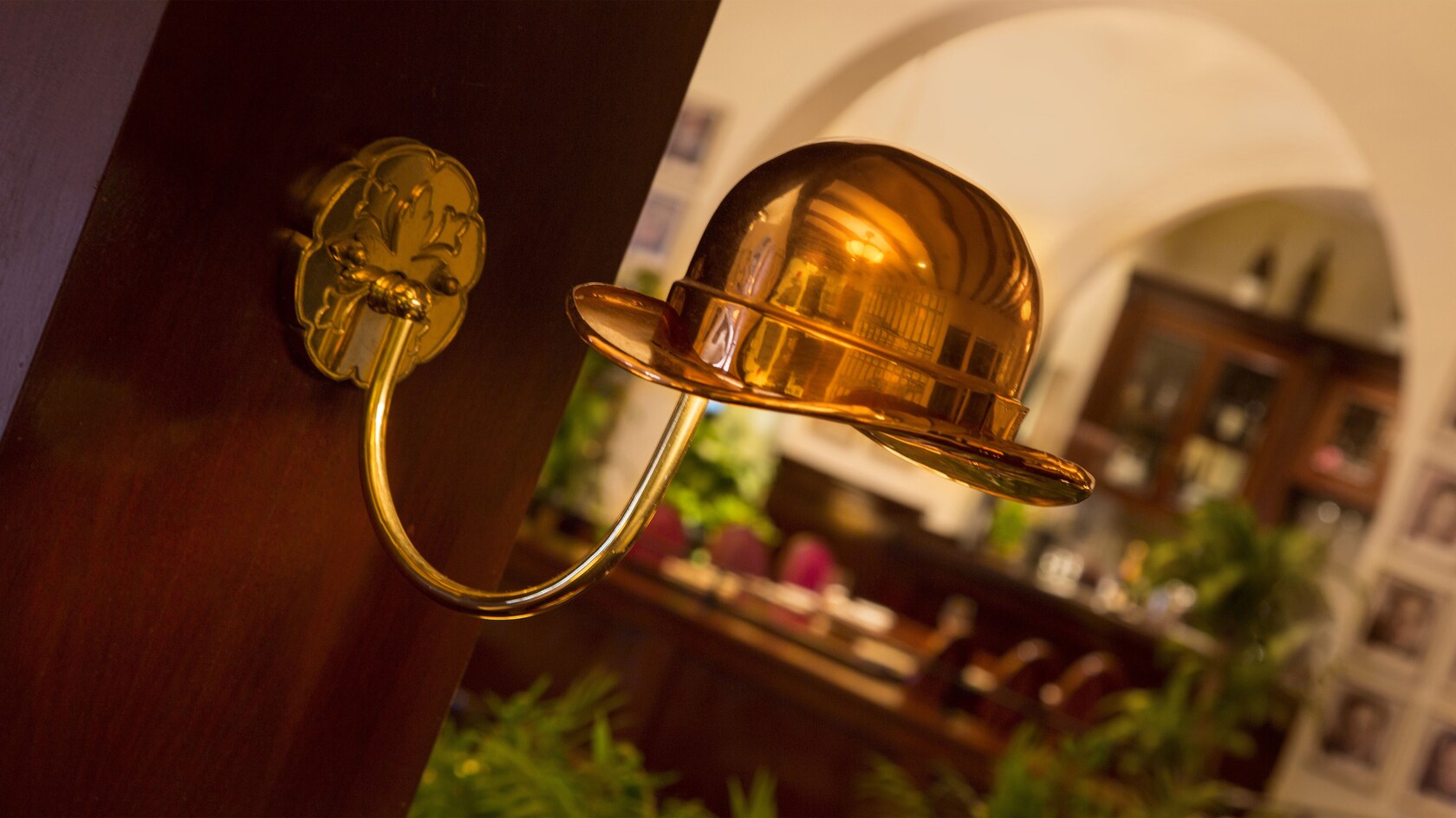 Copper lamp in the shape of a derby hat attached to wood panel