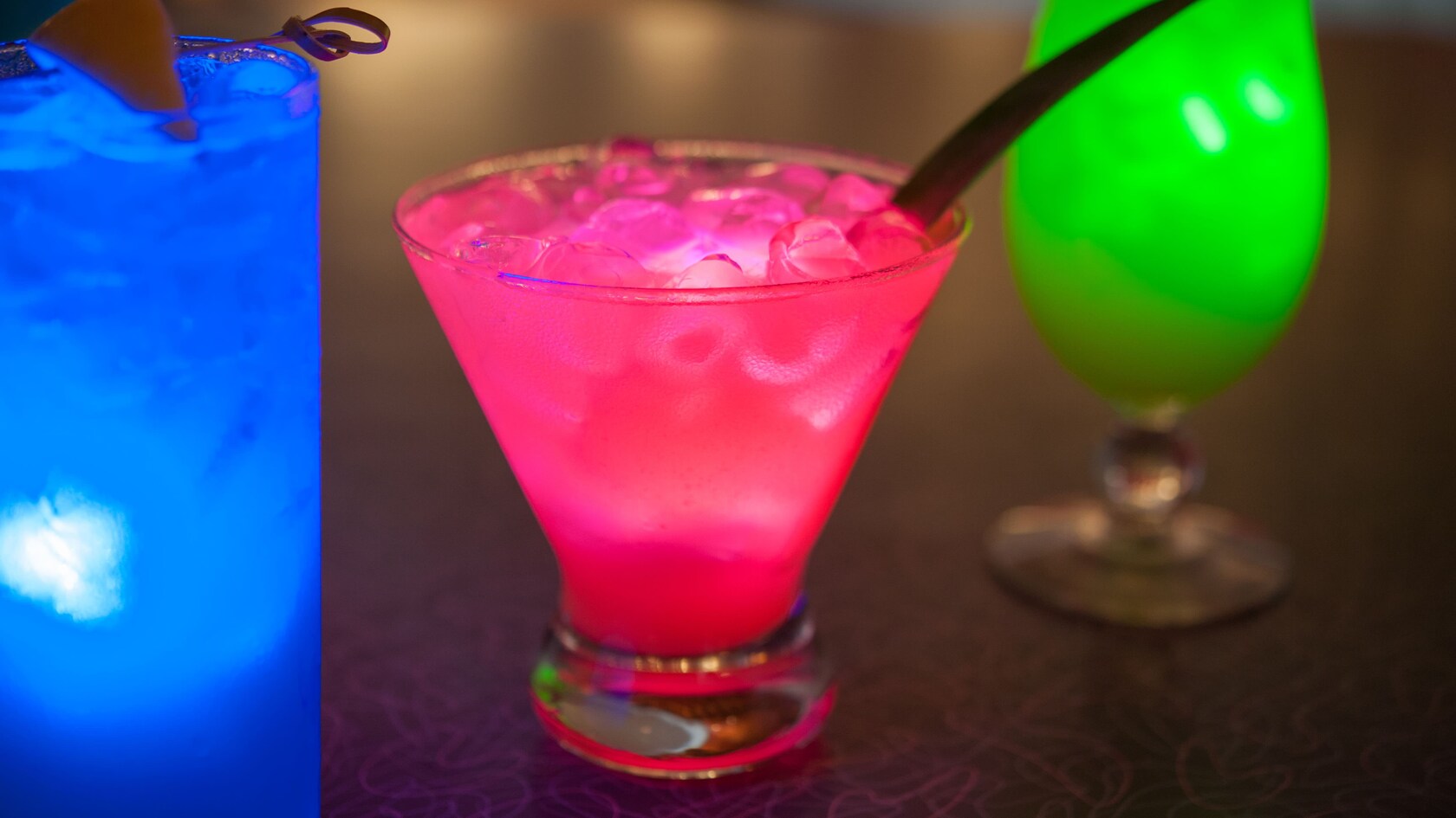 Close-up of 3 specialty cocktails, each a different color