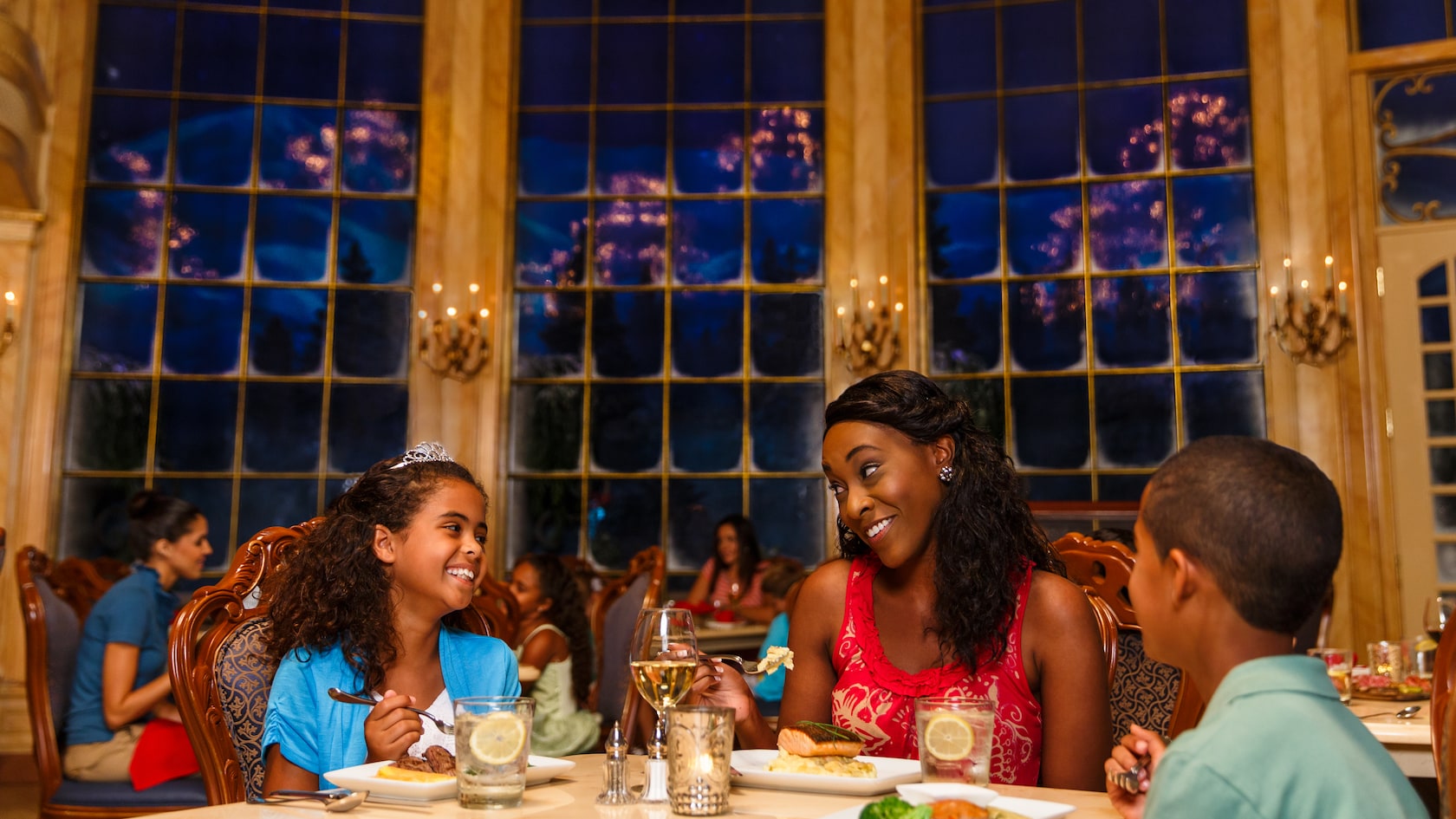 Una madre y sus hijos disfrutan la cena en el restaurante Be Our Guest en Fantasyland