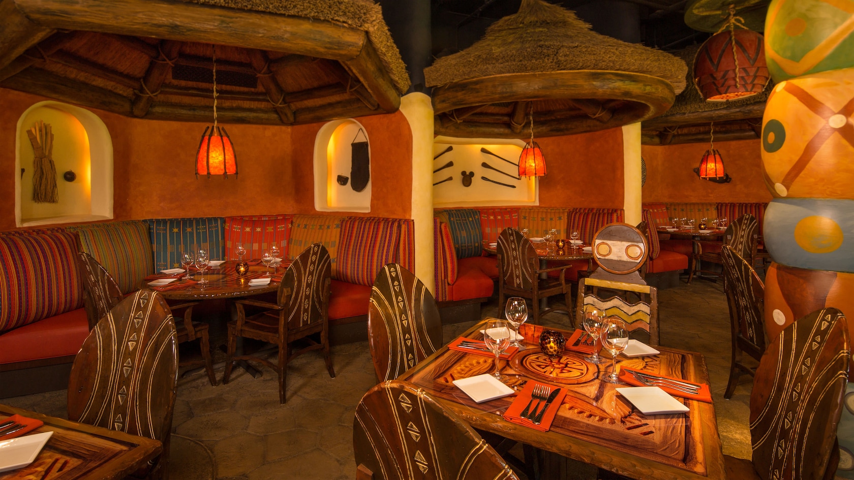 Tribal-design tables under hanging thatched domes with lanterns