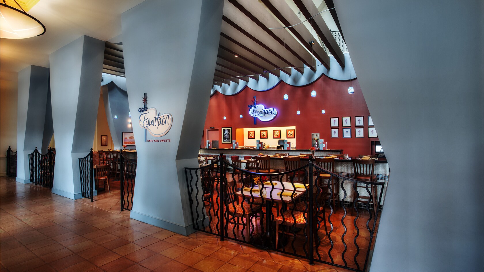 Corredor de azulejo separado de uma sala de jantar no The Fountain por um portão de ferro forjado