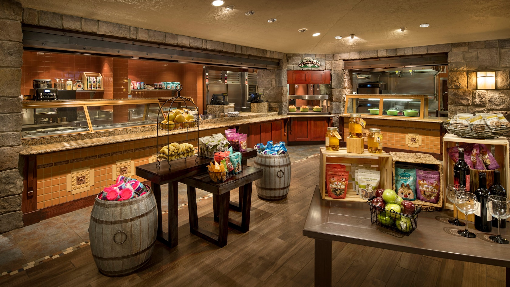 Uma cafeteria com várias estações de alimentação e 2 mesas repletas de lanches.