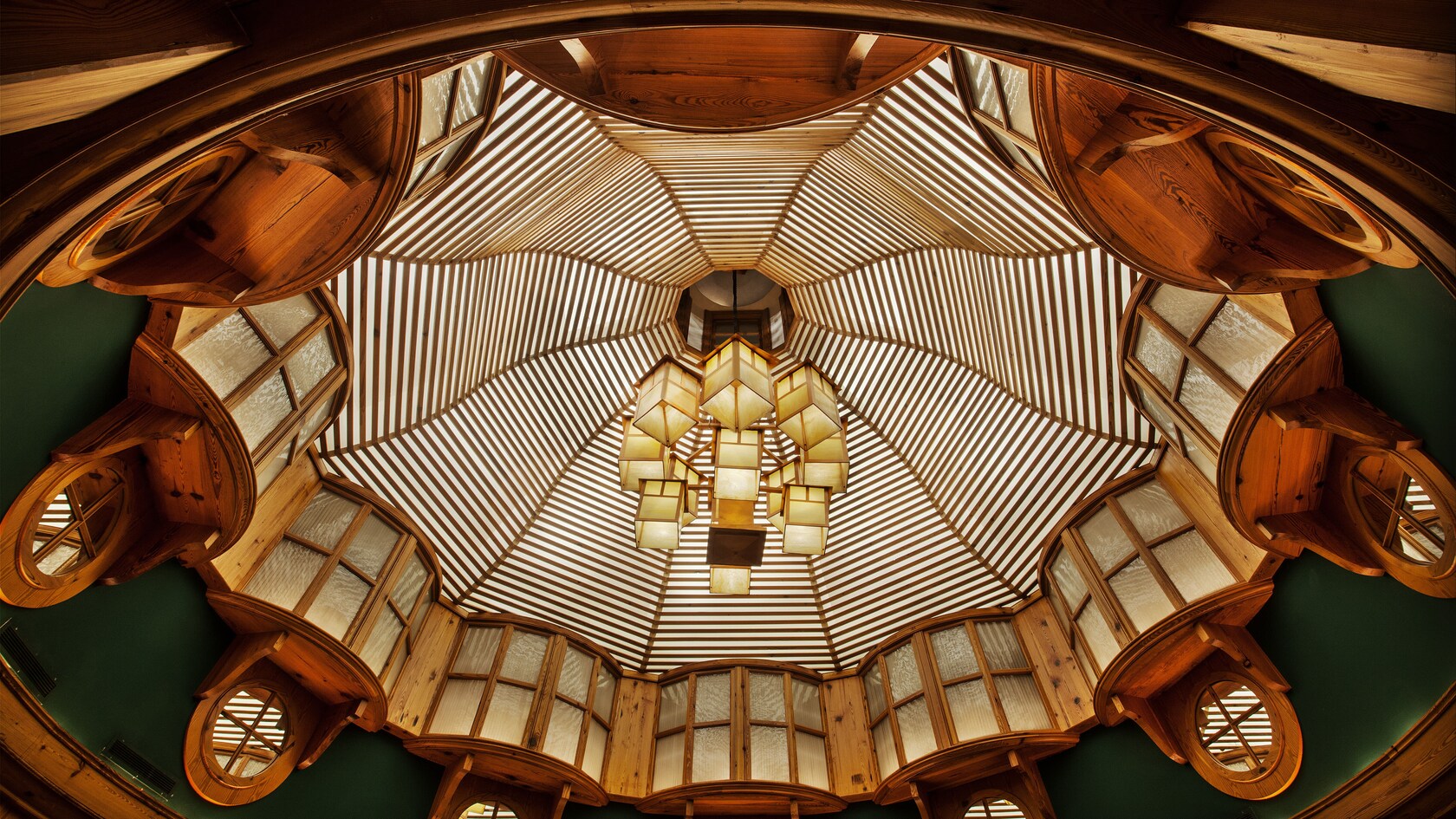 Vaulted ceiling with a linear design, box-like chandeliers and convex windows