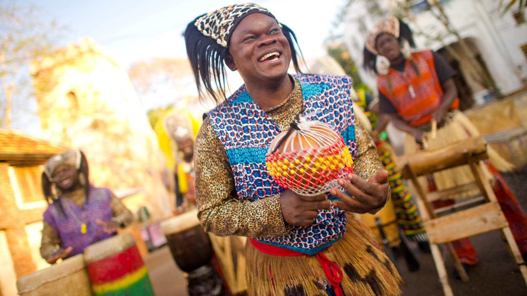 Un bailarín sonriente actúa como presentador de los Tam Tam Drummers of Harambe