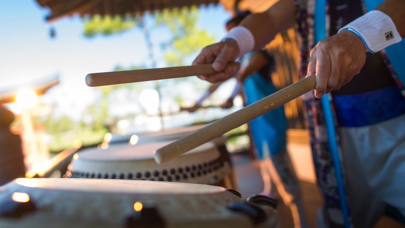 Les baguettes de tambour d'un membre de Matsuriza frappent un tambour Taiko au pavillon japonais