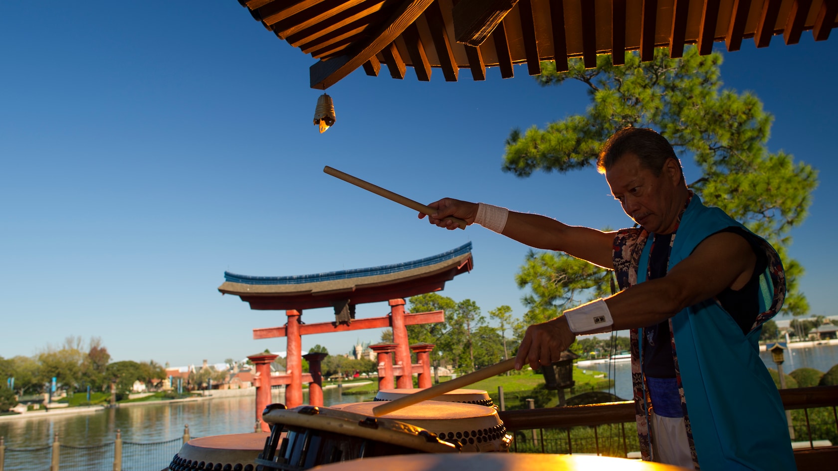 Un membre de la troupe Matsuriza joue sur des tambours Taiko devant la porte Torii