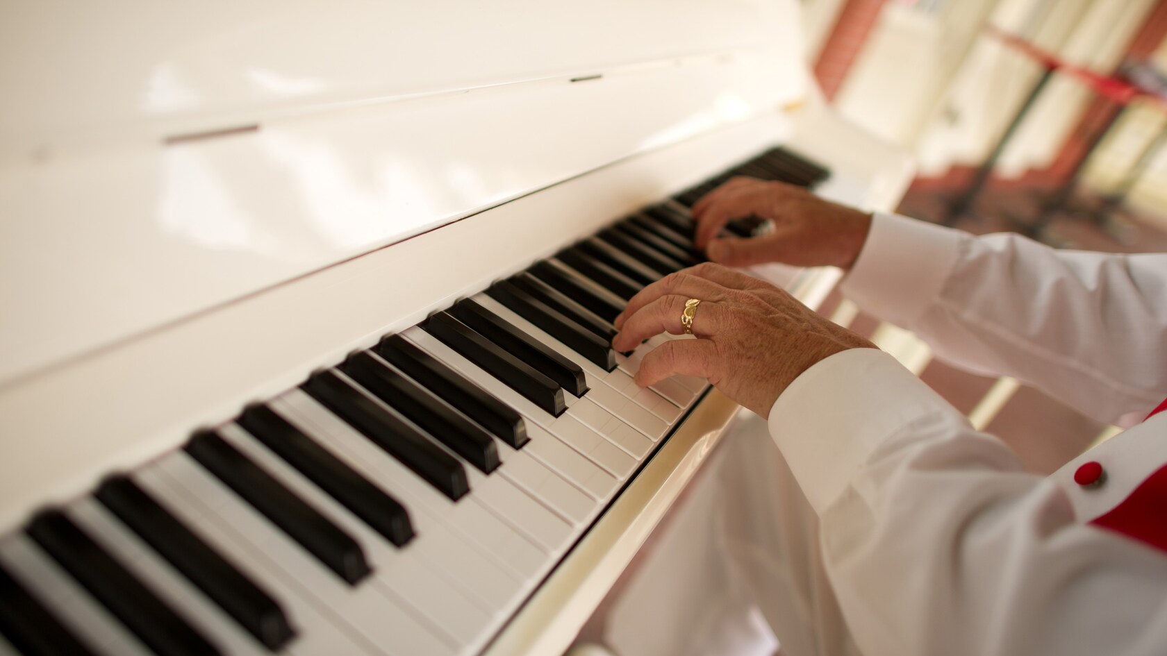 The hands of a pianist glide over the keys of a piano at Casey's Corner