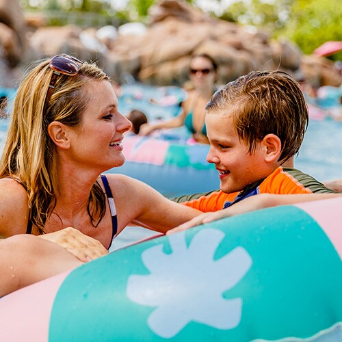 A mother plays with her son who's sitting in an inner tube in Melt-Away Bay