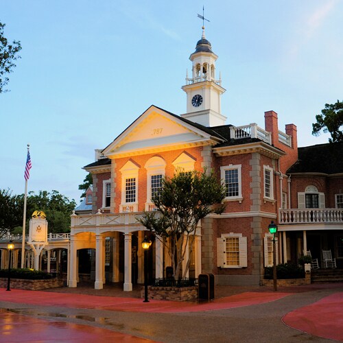 The Colonial brick building of the Hall of Presidents has a clock tower with a bell and a weather vane