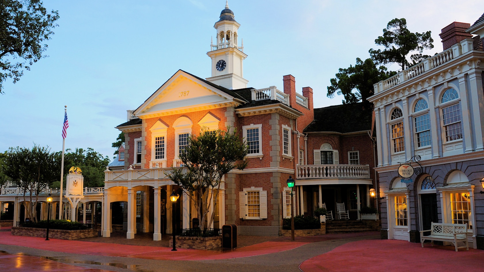 The Colonial brick building of the Hall of Presidents has a clock tower with a bell and a weather vane