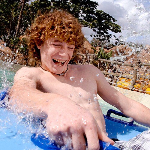 A teenager holds on tightly to his inner tube as he rides Keelhaul Falls
