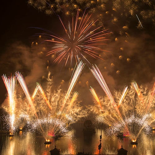 Fourth of July fireworks bursting above World Showcase Lagoon at Walt Disney World