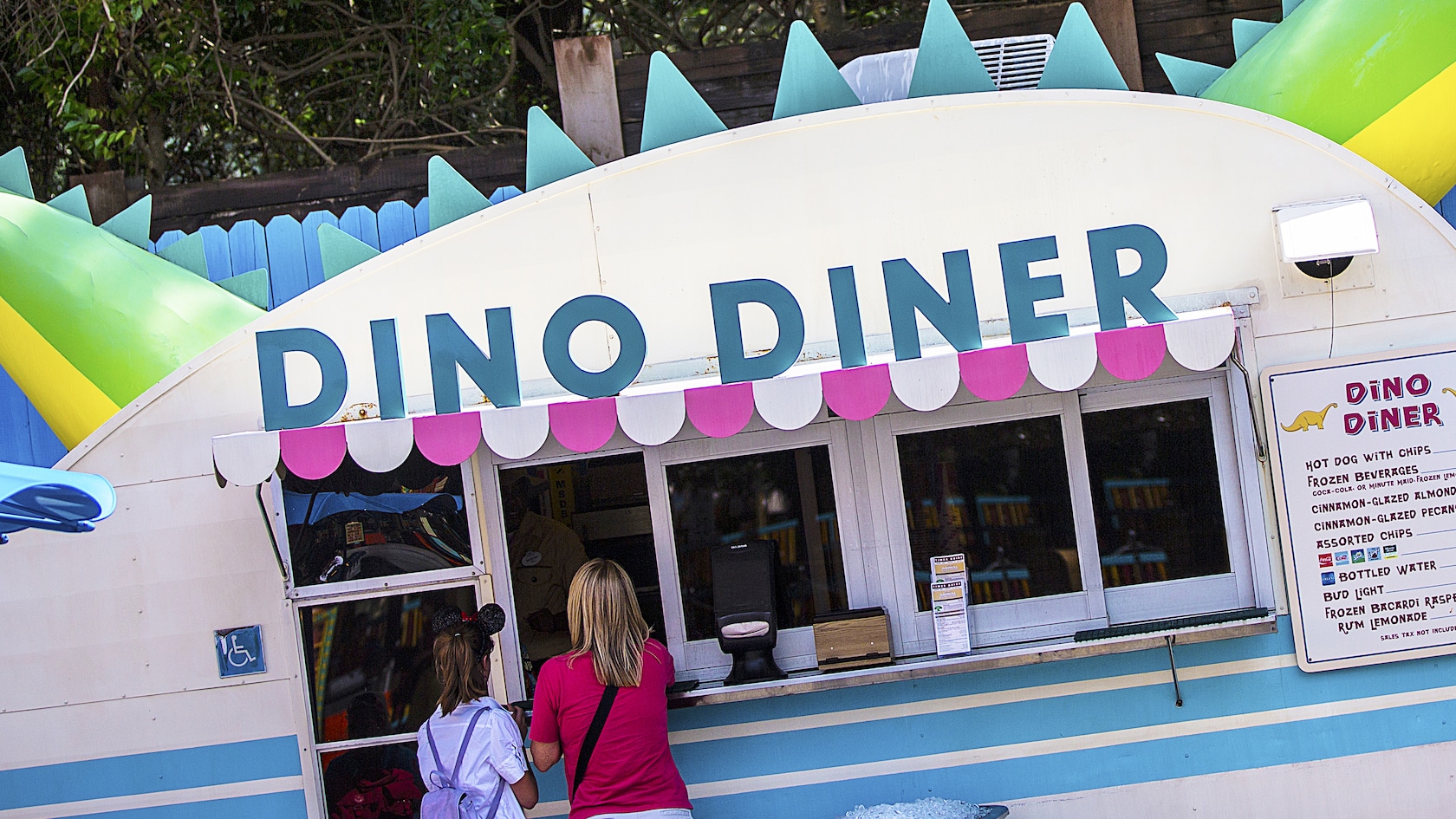 Guests line up to place an order outside the Dino-Diner trailer, with its dinosaur-themed décor