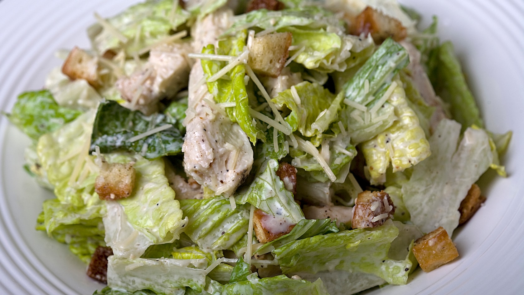 A salad made with lettuce, chicken breast and Caesar dressing