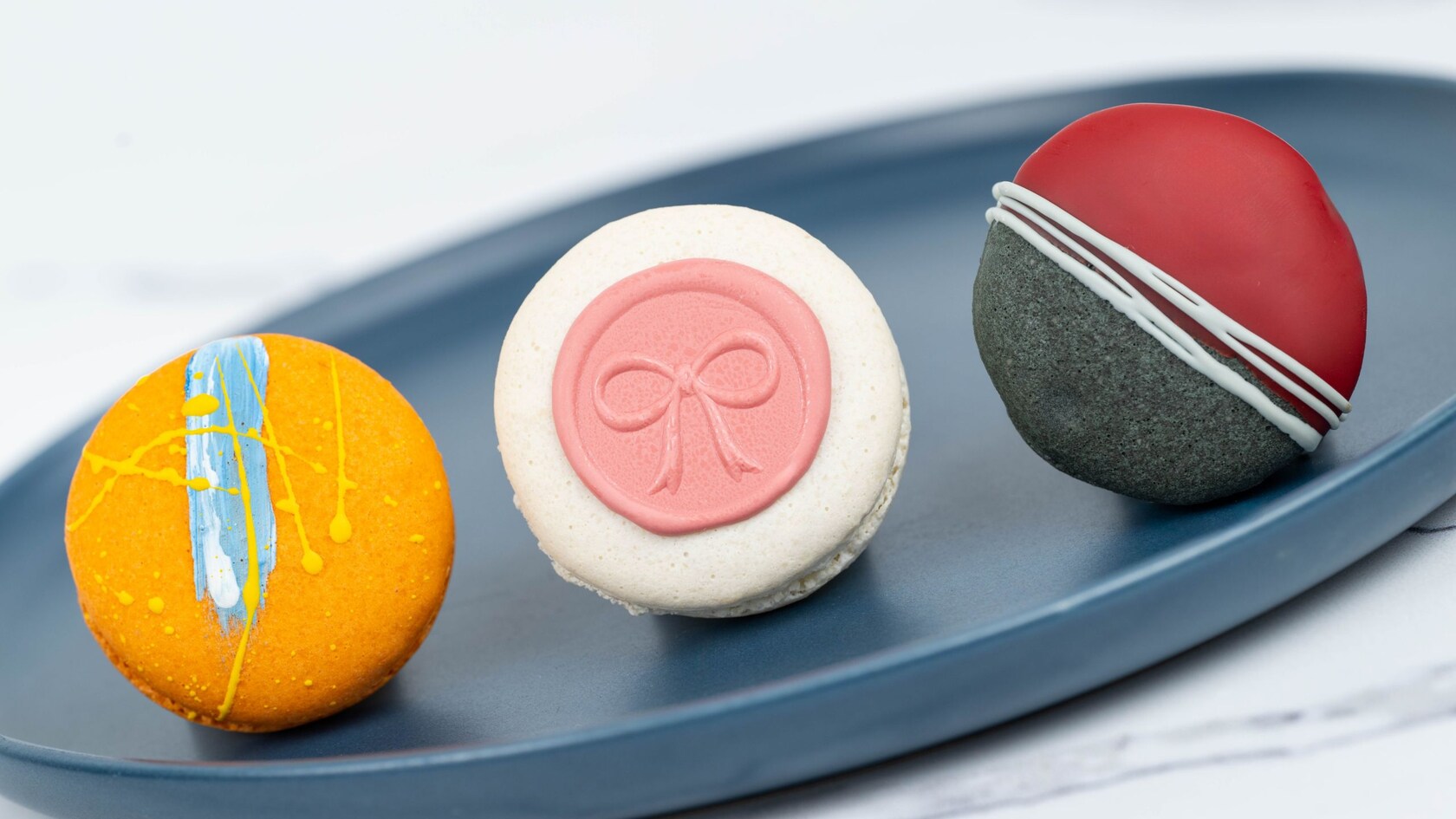 Uma bandeja com marshmallow de laranja, geleia de morango e macarons com ganache de espresso