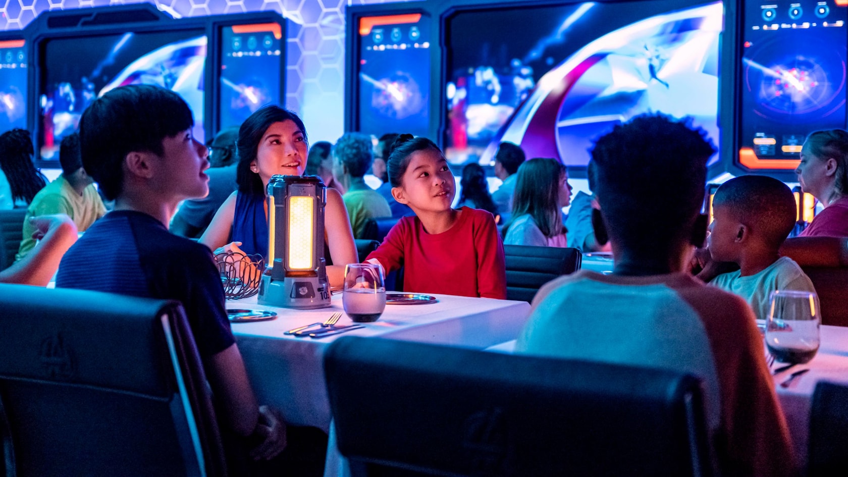 A group of children watching something fascinating while in a Marvel themed restaurant