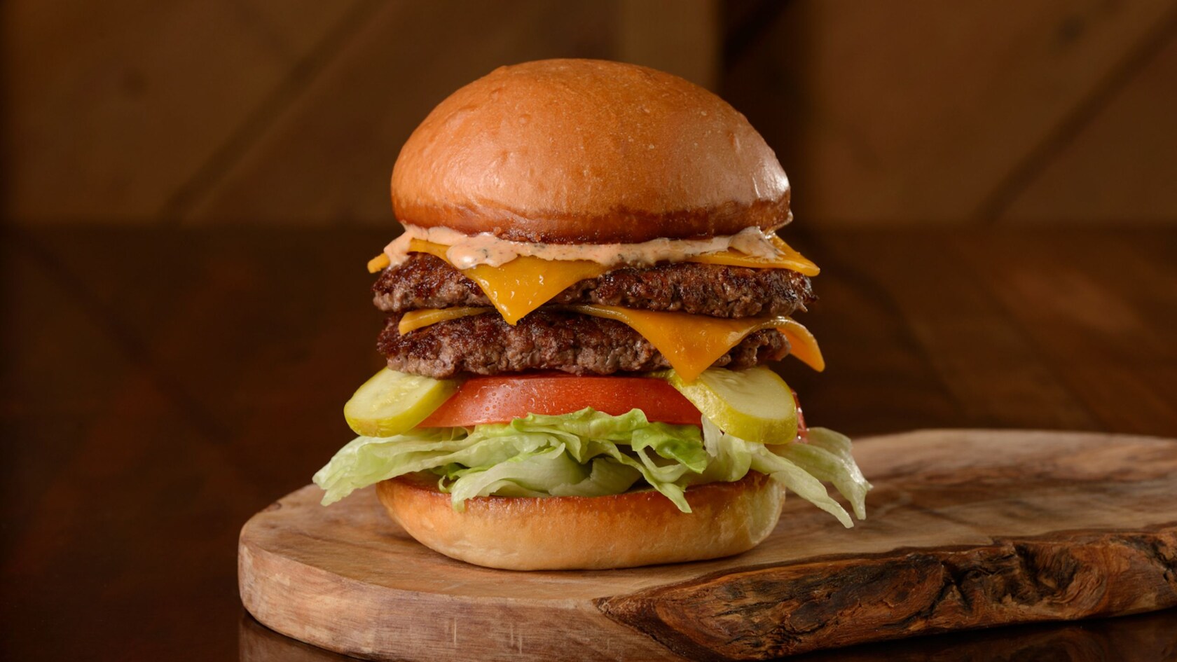 A cheeseburger with 2 patties, cheese, pickles, tomato, lettuce and sauce