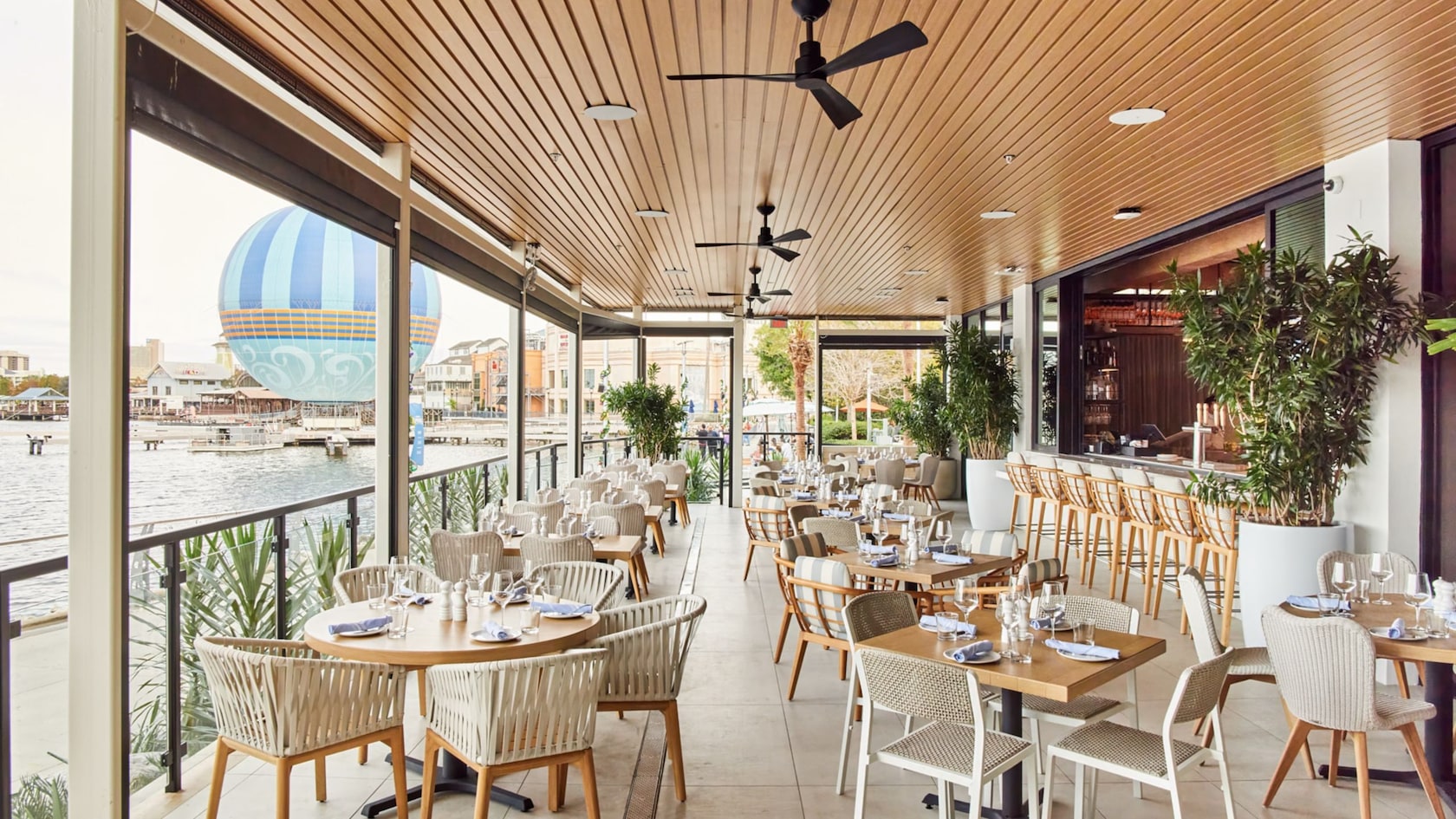 Varias mesas de restaurante dispuestas en un patio junto al lago