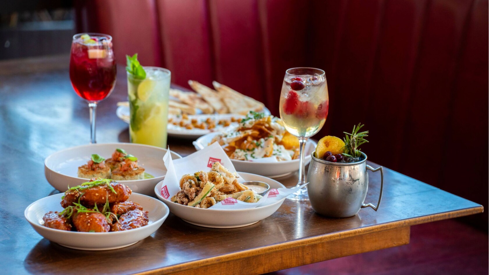 A table holding several bowls of food and iced beverages
