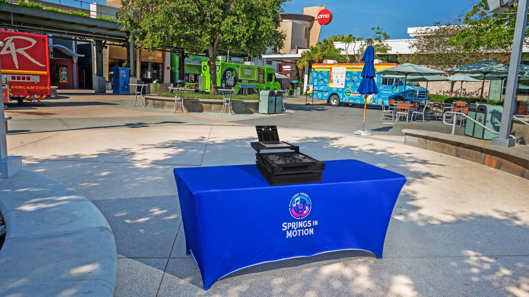 A table with musical equipment surrounded by a variety of food trucks at Exposition Park in Disney Springs