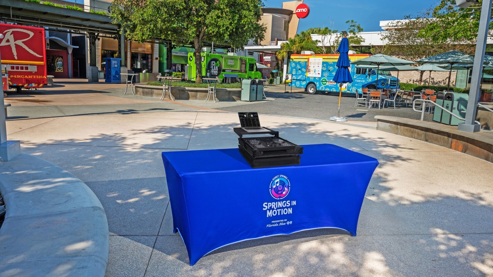 A table with musical equipment surrounded by a variety of food trucks at Exposition Park in Disney Springs